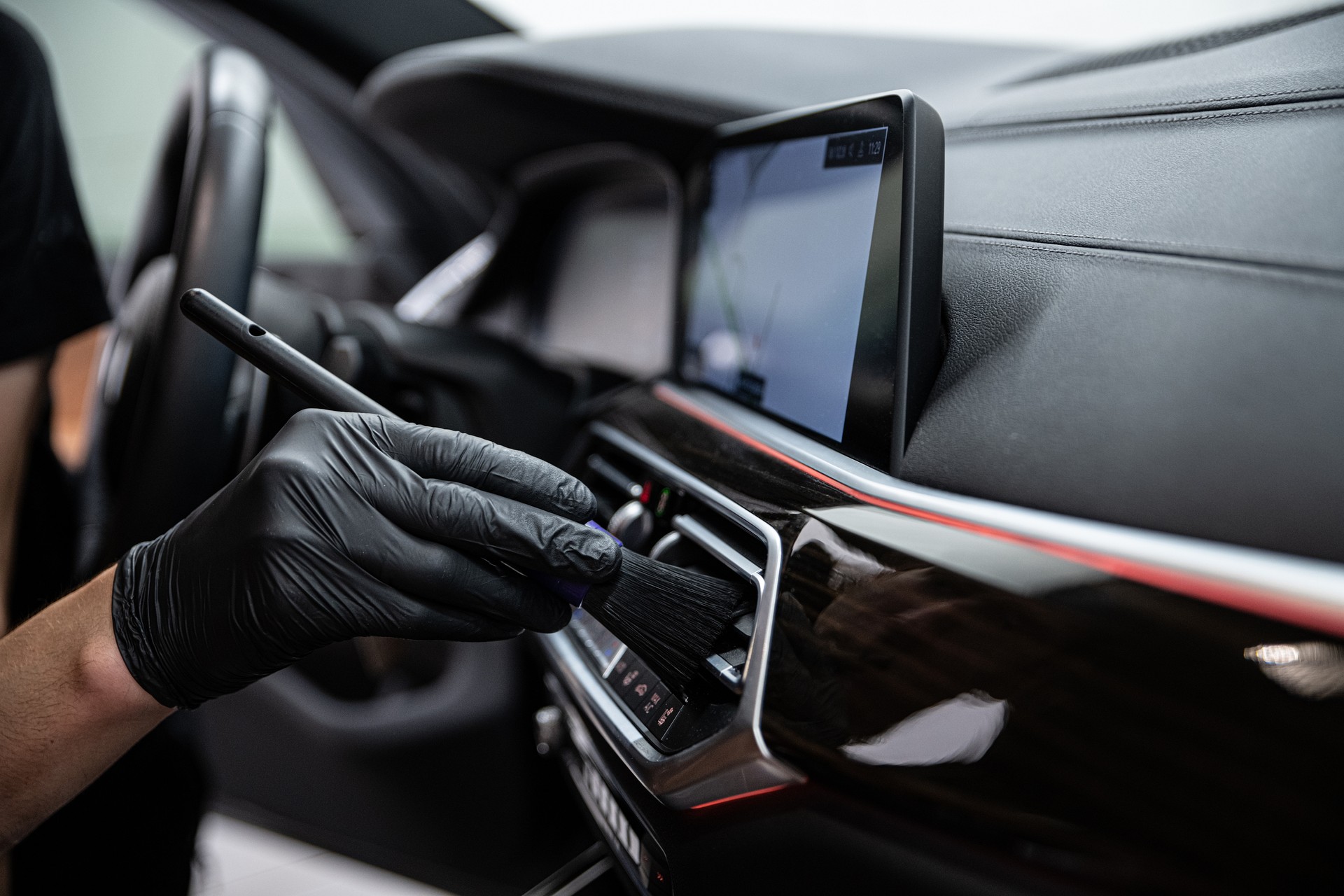 car detailing studio employee carefully cleans the air vents